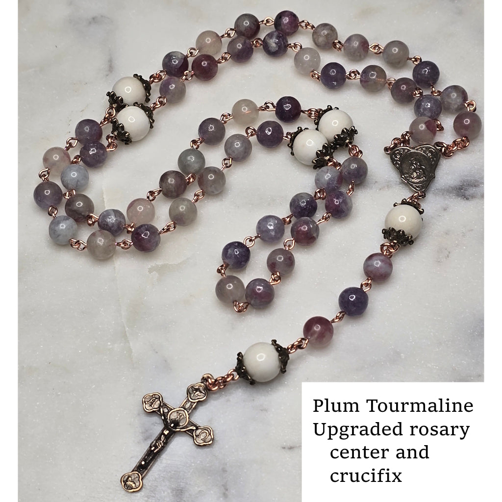 Plum Tourmaline rosary with Breast Milk Our Father/Glory Be beads and crucifix on a marble surface