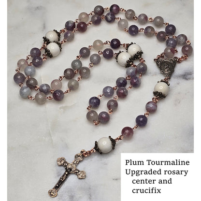 Plum Tourmaline rosary with Breast Milk Our Father/Glory Be beads and crucifix on a marble surface