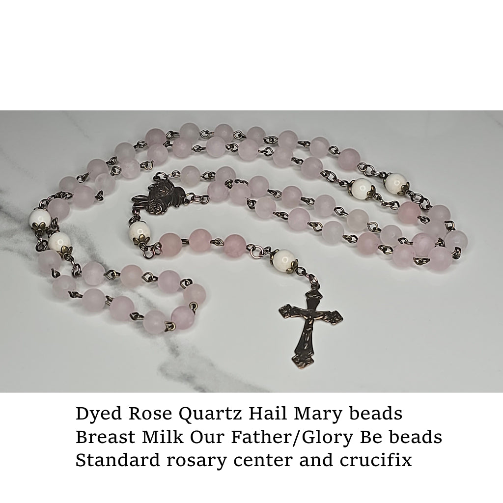 Rosary with Rose Quartz Hail Mary beads with crucifix on a marble surface