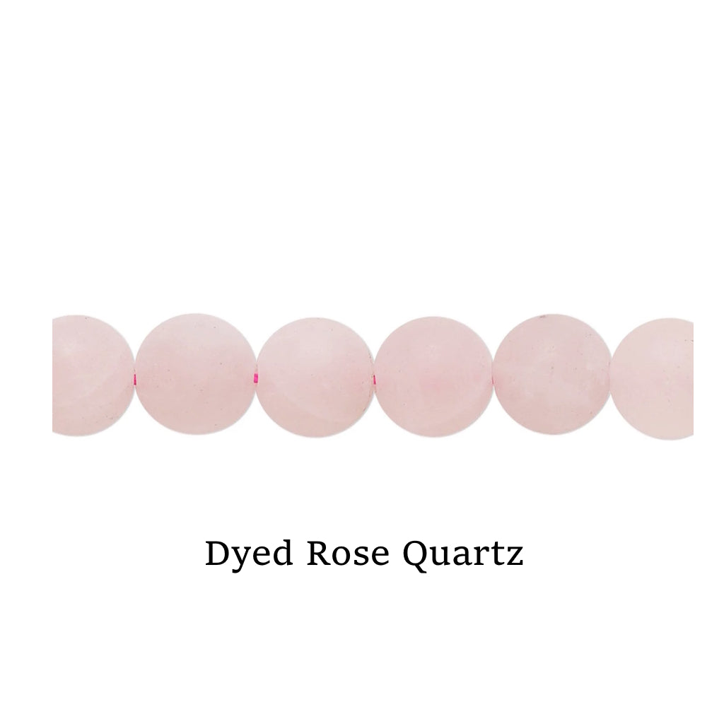 Line of pink Dyed Rose Quartz beads on a white surface