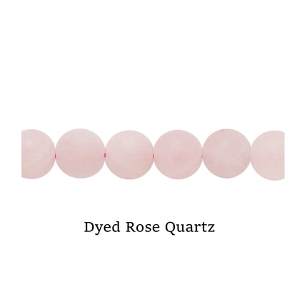 Line of pink Dyed Rose Quartz beads on a white surface