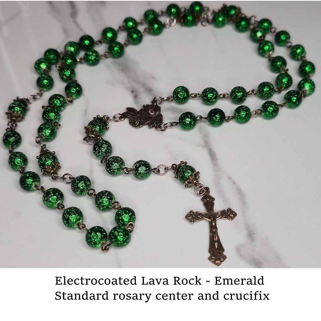 Electrocoated green lava rock rosary with crucifix on a marble surface