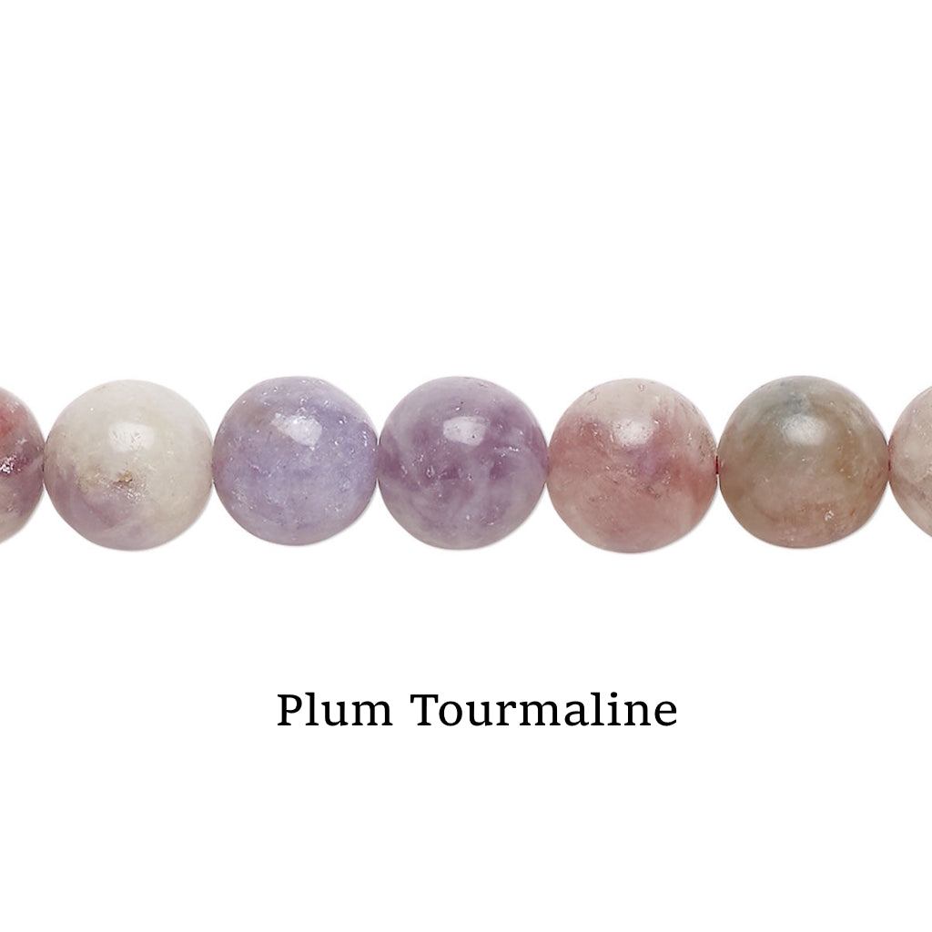 Row of plum tourmaline beads on a white surface